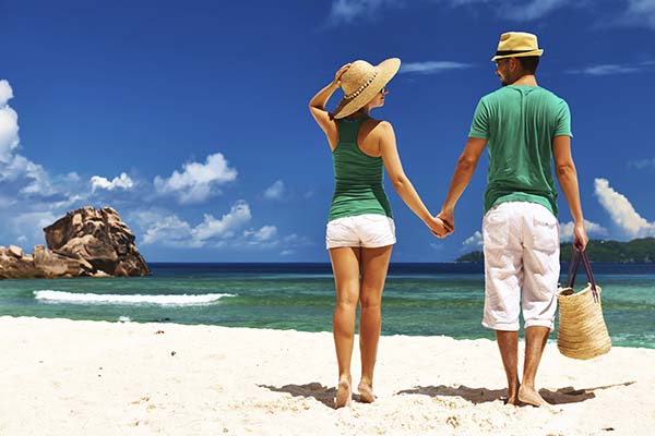 Couple relaxing on a tropical beach at Seychelles, La Digue.