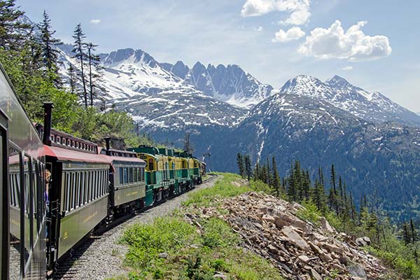 White Pass & Yukon Route Railroad travels along the cliffs heading towards Skagway, Alaska